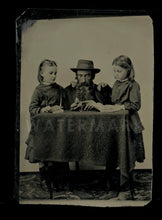 Load image into Gallery viewer, intriguing tintype man showing open watch or photo locket to little girls 1800s
