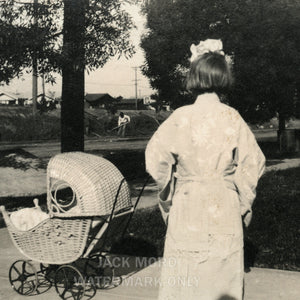 snapshot photo girl turned away from camera with doll stroller, unusual creepy
